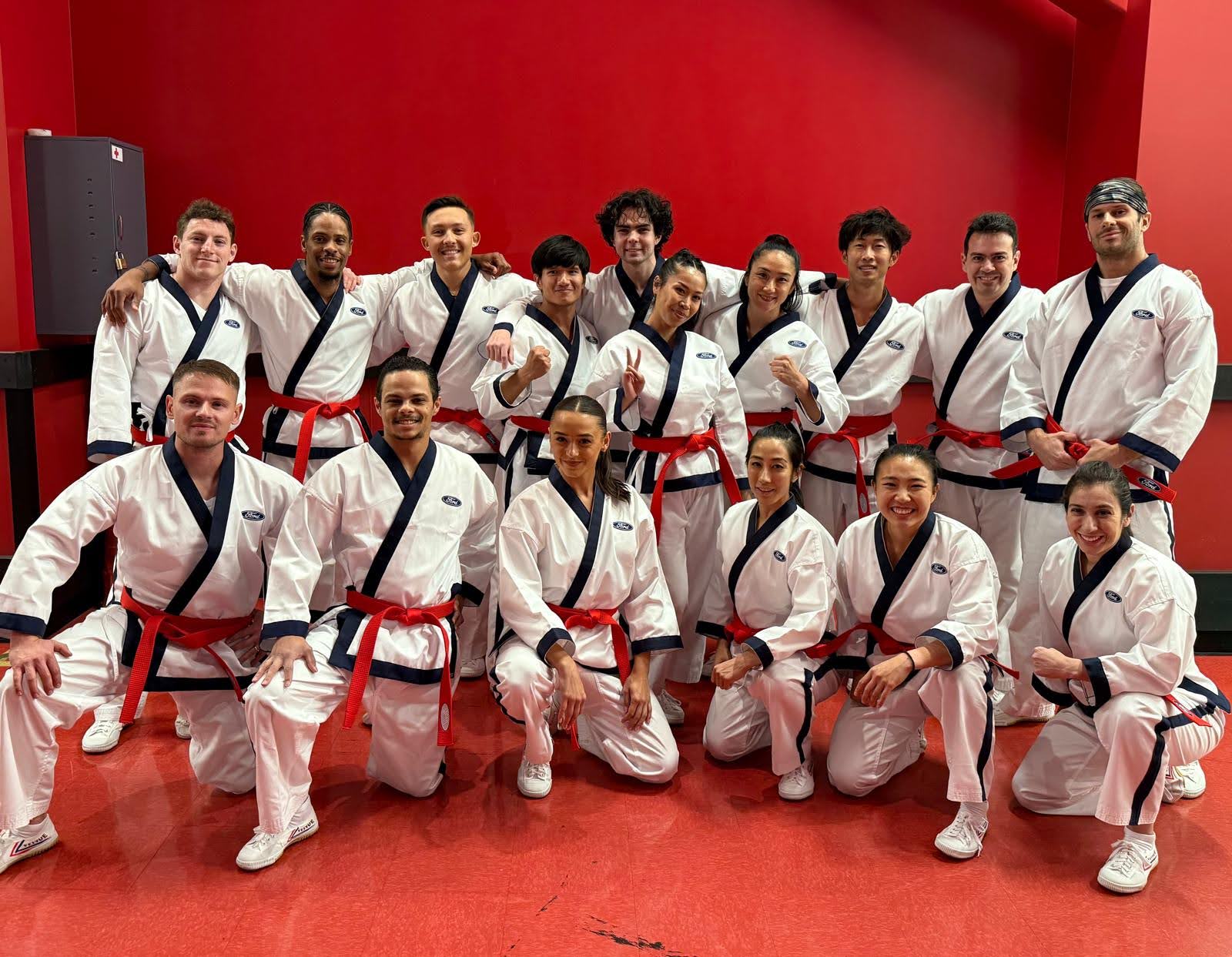 Group photo of a martial arts demo team in Ford-branded uniforms